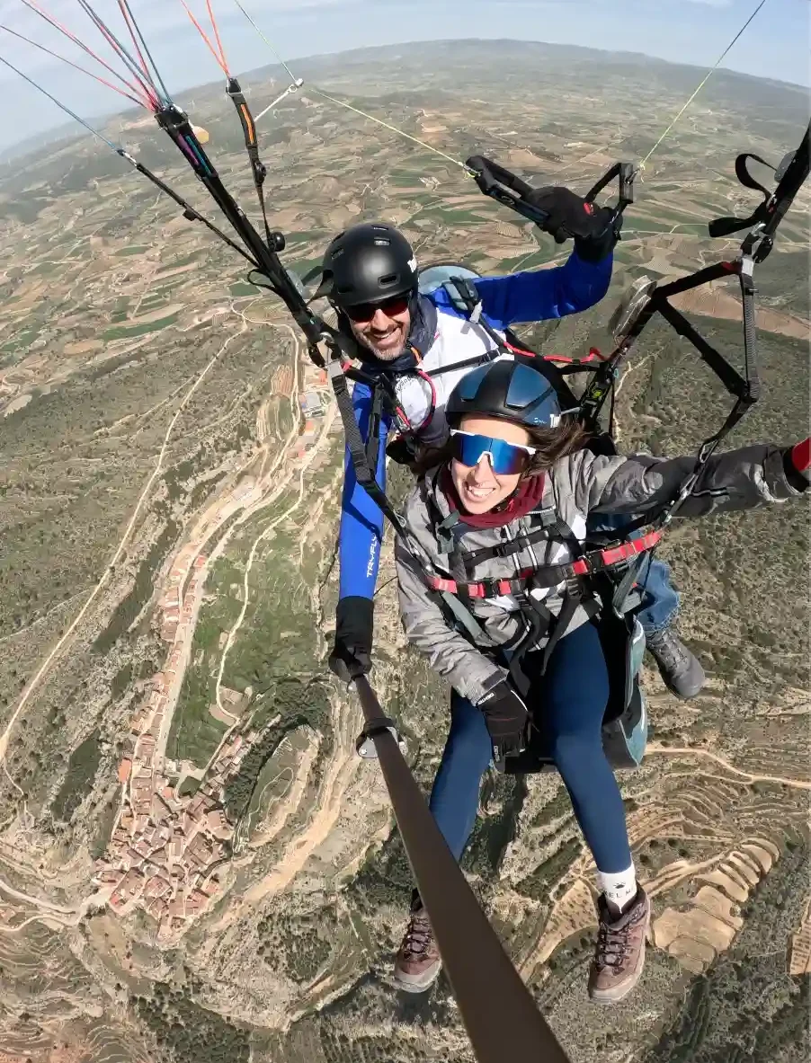 Persona disfrutando de un vuelo en parapente biplaza con instructor en la provincia de Valencia