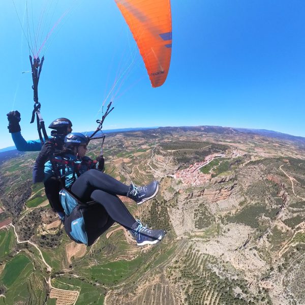 "Persona disfrutando de un vuelo en parapente biplaza con instructor en la provincia de Valencia"