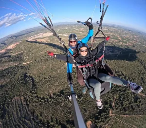 Persona disfrutando de un vuelo en parapente biplaza con instructor en la provincia de Valencia