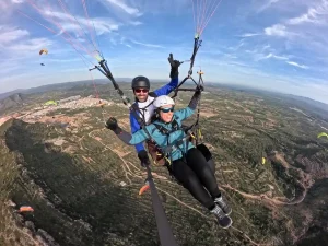 Persona disfrutando de un vuelo en parapente biplaza con instructor en la provincia de Valencia