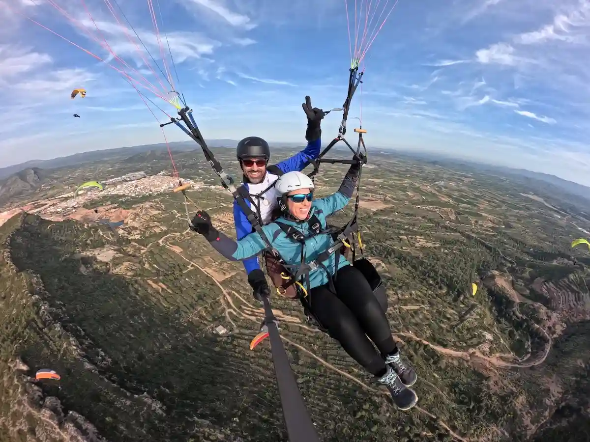 Persona disfrutando de un vuelo en parapente biplaza con instructor en la provincia de Valencia