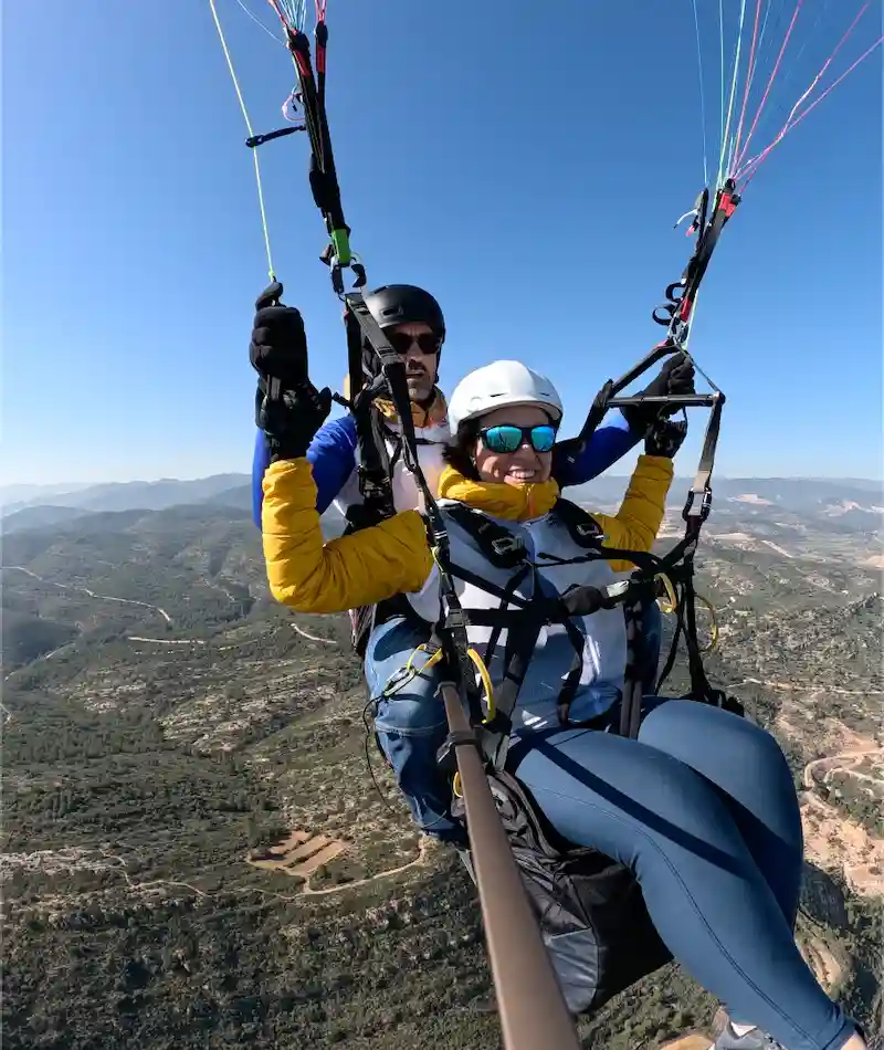 Persona disfrutando de un vuelo en parapente biplaza con instructor en la provincia de Valencia