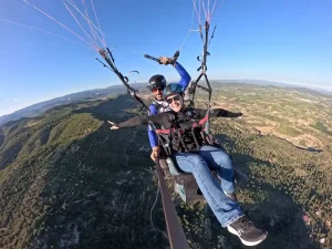 Persona disfrutando de un vuelo en parapente biplaza con instructor en la provincia de Valencia