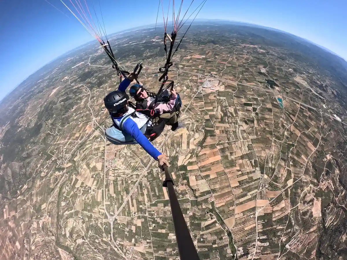 Persona disfrutando de un vuelo en parapente biplaza con instructor en la provincia de Valencia